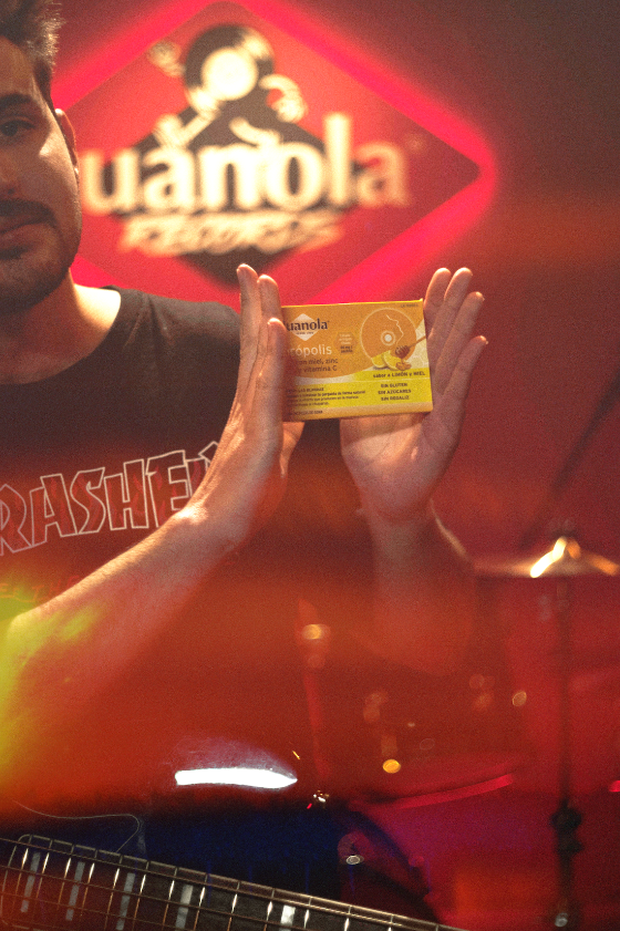 Juanola Records — artist holding the Juanola pack under the neon sign